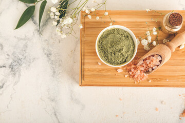 Dry henna powder in bowl and sea salt on light background