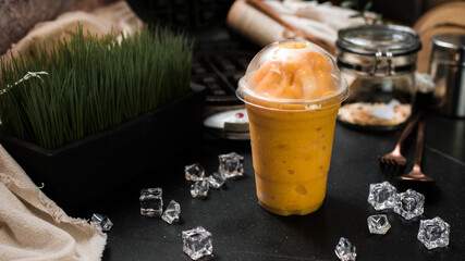 mango smoothie served on black table at cafe​