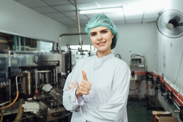 worker thumbs up in production line at drinks production factory background