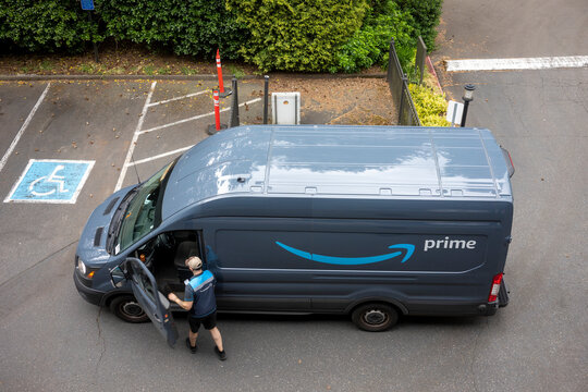 Lake Oswego, OR, USA - May 20, 2021: An Amazon delivery driver and his van are seen in a neighborhood parking lot in Lake Oswego, Oregon.
