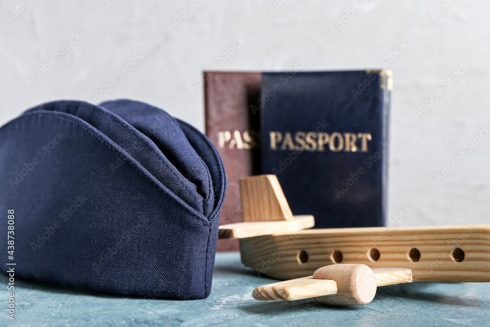 Canvas Prints Stewardess hat with passport and plane figure on light background