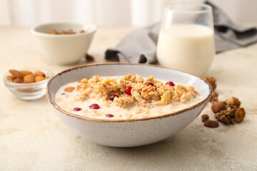 Tasty granola with milk on table