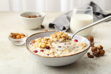 Tasty granola with milk on table