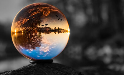 Crystal ball sunset shot with black and white background outside the sphere near Pleinting, Bavaria, Germany