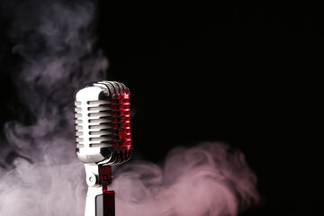 Retro microphone on dark background with fume