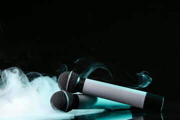 Modern microphones on dark background with fume