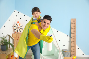 Father and son with cleaning supplies having fun at home