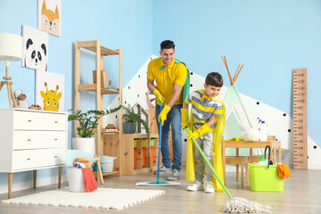 Father and son with mopping floor at home