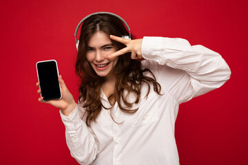 Beautiful happy smiling young woman wearing stylish casual outfit isolated on background wall...