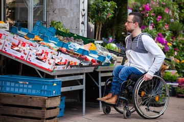 man in wheelchair shopping for fruits and vegetables at market