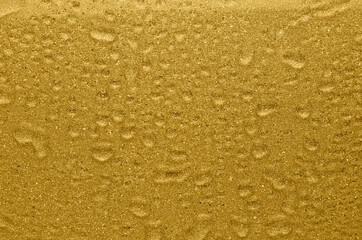 Golden shimmer and glitter wet texture with drops. Rich golden background.