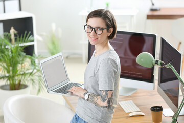 Female programmer working with laptop in office