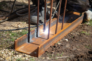 A welder welds metal at a construction site.