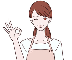 OKマークをつくるエプロン姿の女性