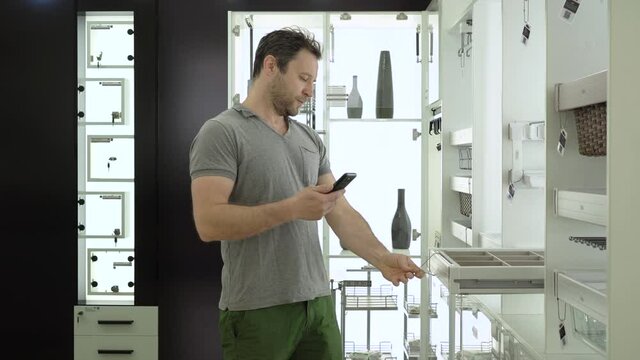 The buyer chooses furniture components. Scanning the QR code at the exhibition stand with a smartphone. Adding an item to the cart in the app. Selection of kitchen furniture.