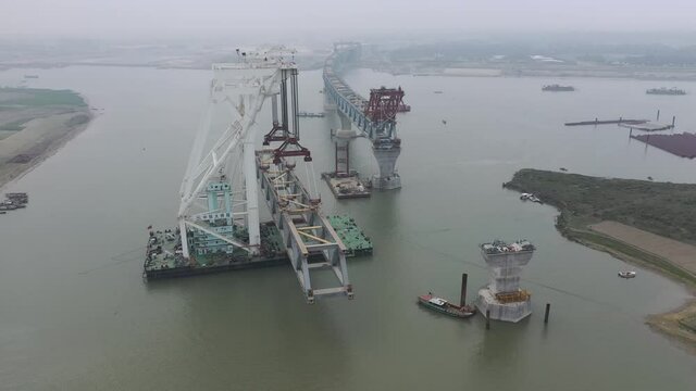 Aerial view of a building site while assembling the Padma bridge, the longest rail and highway bridge in Bangladesh crossing the Padma river, Zajira, Dhaka, Bangladesh.