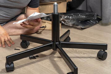 man assembles a chair according to instructions