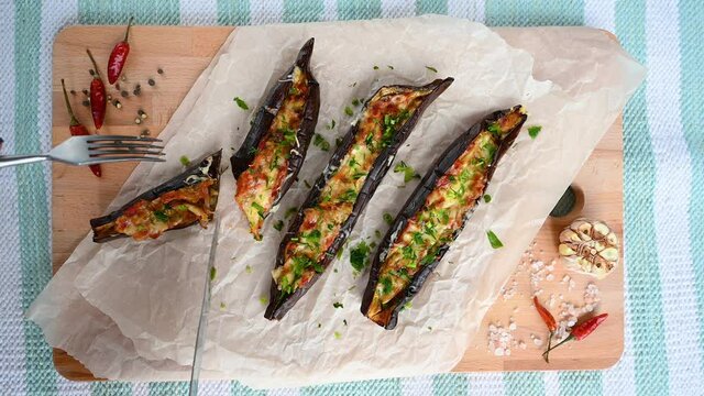 4k video cut the halves of stuffed eggplant on a wooden board
