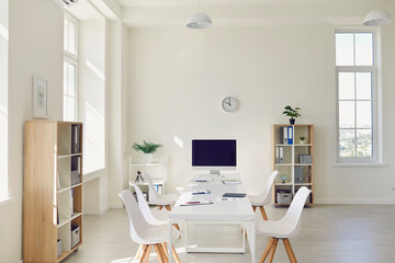 Interior of cozy light boardroom with big table, modern chairs and desktop computer