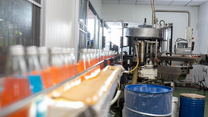 factory spilling juice bottles into glass bottles on conveyor lines. Industrial work, automated production of food and drinks. Glass products. Bottles for drinks.