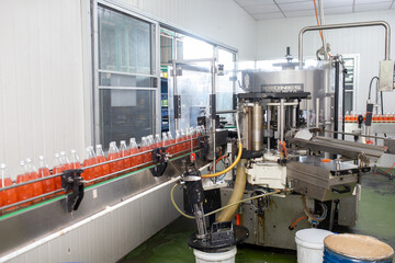 factory spilling juice bottles into glass bottles on conveyor lines. Industrial work, automated production of food and drinks. Glass products. Bottles for drinks.