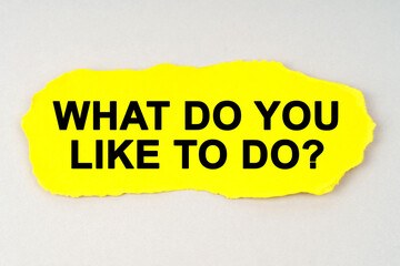 On a white background lies yellow paper with the inscription - WHAT DO YOU LIKE TO DO