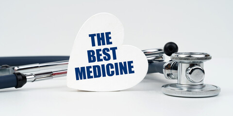 On a white background lies a stethoscope and a heart plate with the inscription - The best medicine