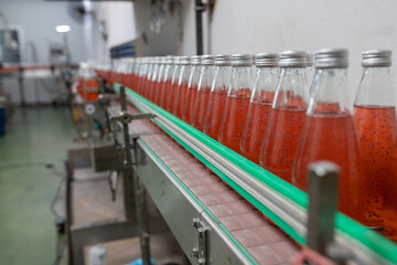 factory spilling juice bottles into glass bottles on conveyor lines. Industrial work, automated production of food and drinks. Glass products. Bottles for drinks.