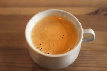 Cappuccino cup on wooden table closeup