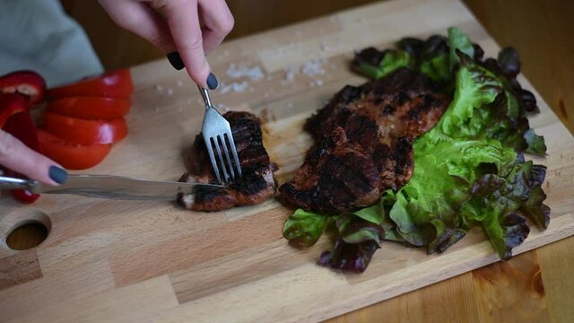 4k video cut a steak on a wooden board, cut meat