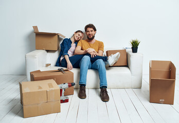 Young family sitting on couch boxes with stuff moving fun
