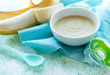 Bowl with fruit baby food and banana