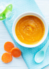 Baby carrot mashed with spoon in bowl