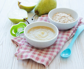 Bowl with fruit baby food and pears
