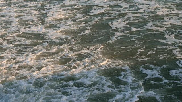 4k video from above waves with sea foam near the shore