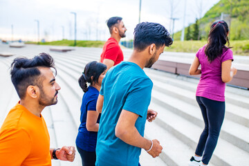 four indian people warming up outdoors in sport wear morning time urban