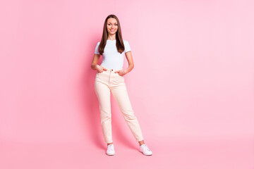 Fototapeta na wymiar Full size photo of young beautiful smiling positive businesswoman hold hands pockets isolated on pink color background