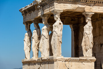 Figures of the Caryatid Porches of Erechtheion on the Acropolis in Athens, Greece with blue Sky...