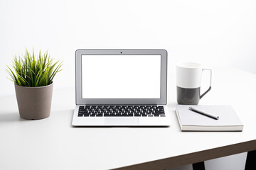 Fototapeta premium Laptop with blank screen on work table. Home office or work space concept