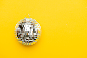 Disco ball on yellow background isolated.