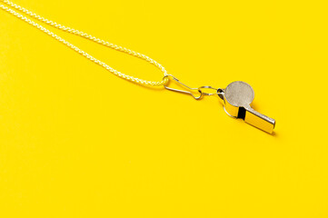 Sports whistle on yellow background. Concept - sport competition, referee, statistics, challenge....