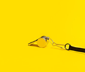 Sports whistle on yellow background. Concept - sport competition, referee, statistics, challenge. Basketball, handball, futsal, volleyball, soccer, baseball, football and hockey referee whistle