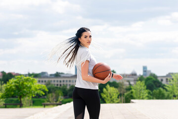 Woman with african braids playing basketball in a park. Youth, lifestyle concept