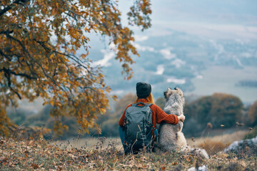 Naklejka na ściany i meble woman hiker next to dog friendship nature mountains travel