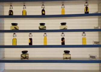 display of different kind of pickled herbs in bottle on a shelve