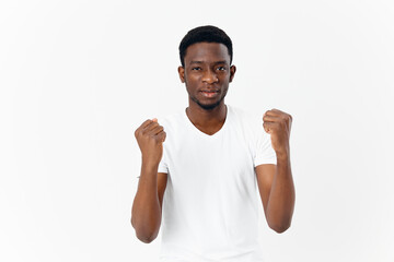 man of african appearance in white t-shirt gestures with hands emotions modern style