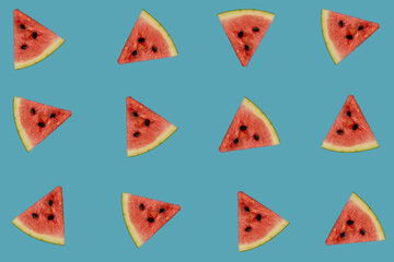 Trendy pattern made of watermelon slices on blue background. Flat lay. Summer concept.