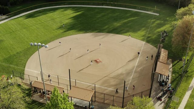 Aerial Drone shot. Kids play school Baseball Field at Park on Sunny Day