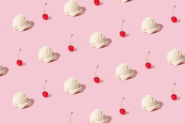 Creative pattern made with ice cream vanilla scoop and bright red cherry on pastel pink background....