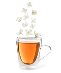 Beautiful jasmine flowers falling into cup of hot freshly brewed tea on white background